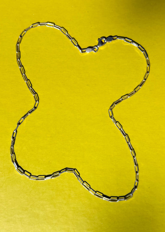Sterling silver chain necklace on a yellow background