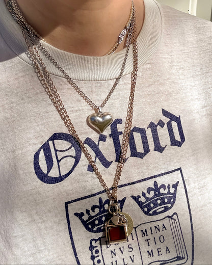 Vintage mixed length silver and gold necklaces styled in a casual way with a T shirt.