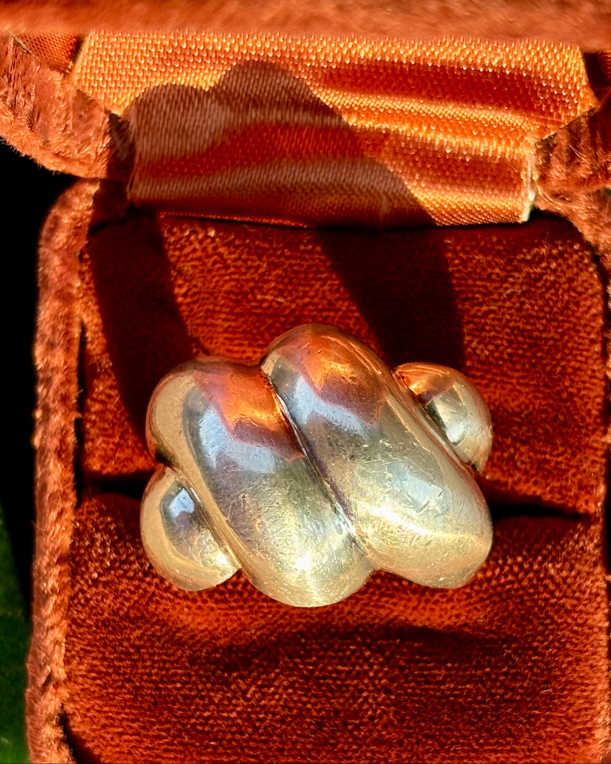 A chunky, organic-shaped silver ring displayed in an open brown velvet jewelry box.