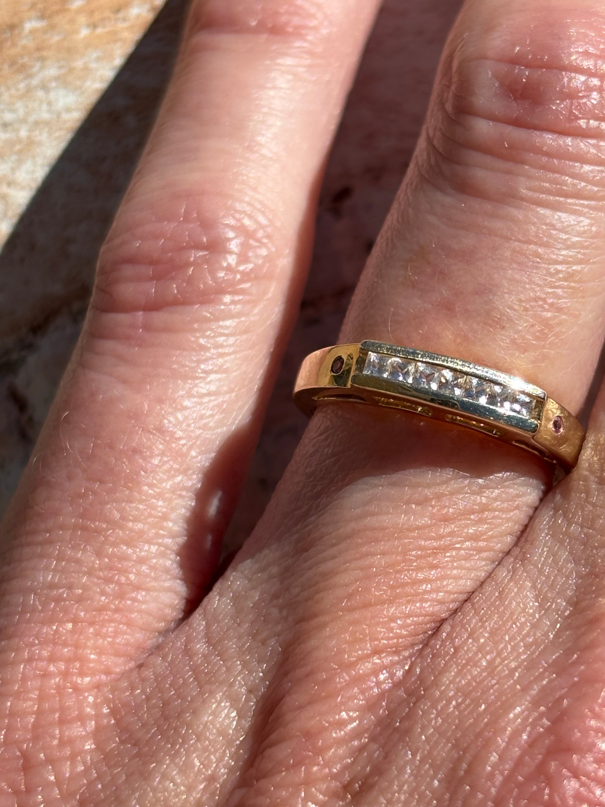 Close-up of a hand wearing a vintage gold band